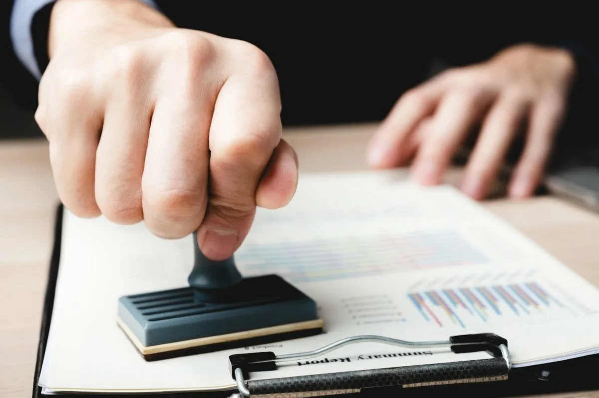 Stampping onto a document symbolising validation or approval in a professional setting.