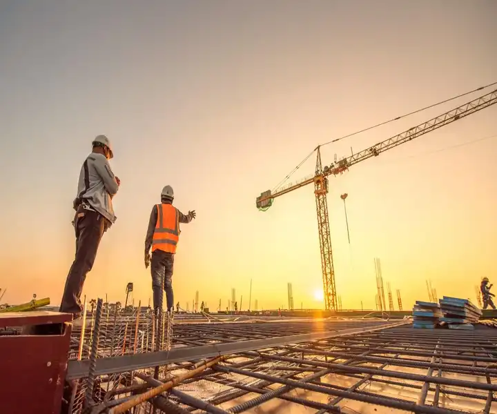 Two engineers oversee a project during the construction to inspect the building work and compliance.