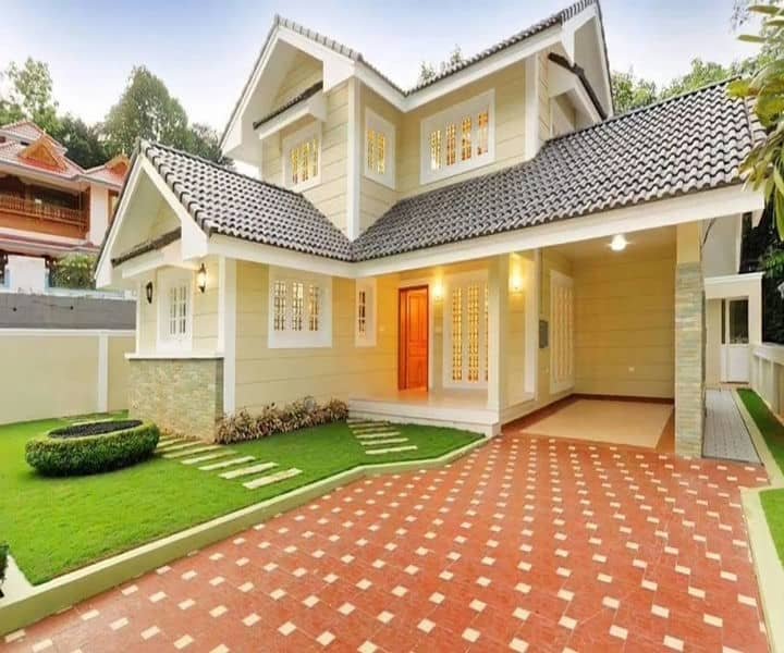 A finalised design of a modern two-story house with a tiled roof, manicured lawn, and decorative pathway, featuring large windows and a welcoming entrance.