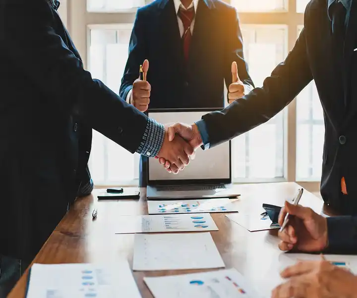 Two persons shaking hands. legal documents are on the table. symbolising that both parties are get agree on some legal consent.