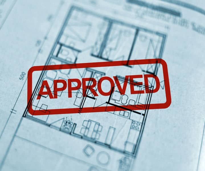 Blueprint of a floor plan marked with a bold red "APPROVED" stamp, indicating official approval for construction.