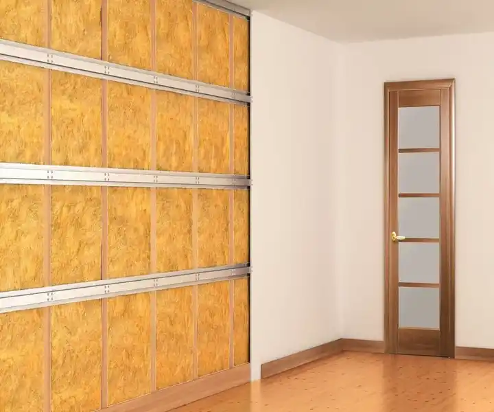 Interior view of a room featuring a wooden door with glass panels and a wall of textured yellow panels framed with metal.