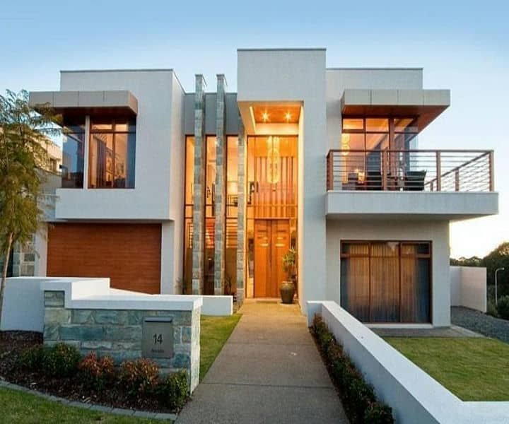 Modern two-story home with large windows, wood accents, and a stone facade, featuring a landscaped front yard and a welcoming entrance.
